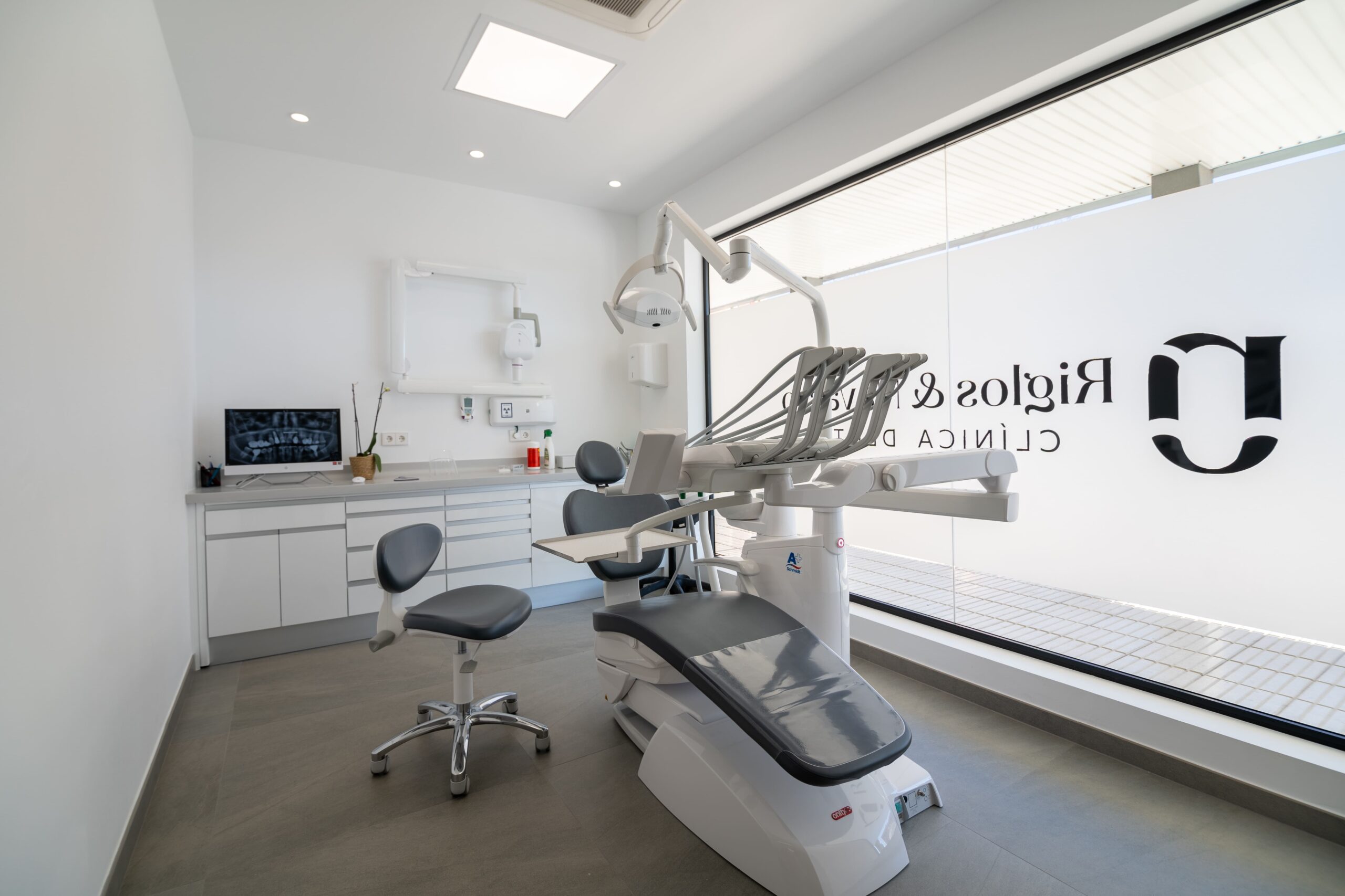 Sala del dentista con la silla para el paciente y la silla al lado del dentista. La sala esta equipada con todo tipo de equipamiento especializado
