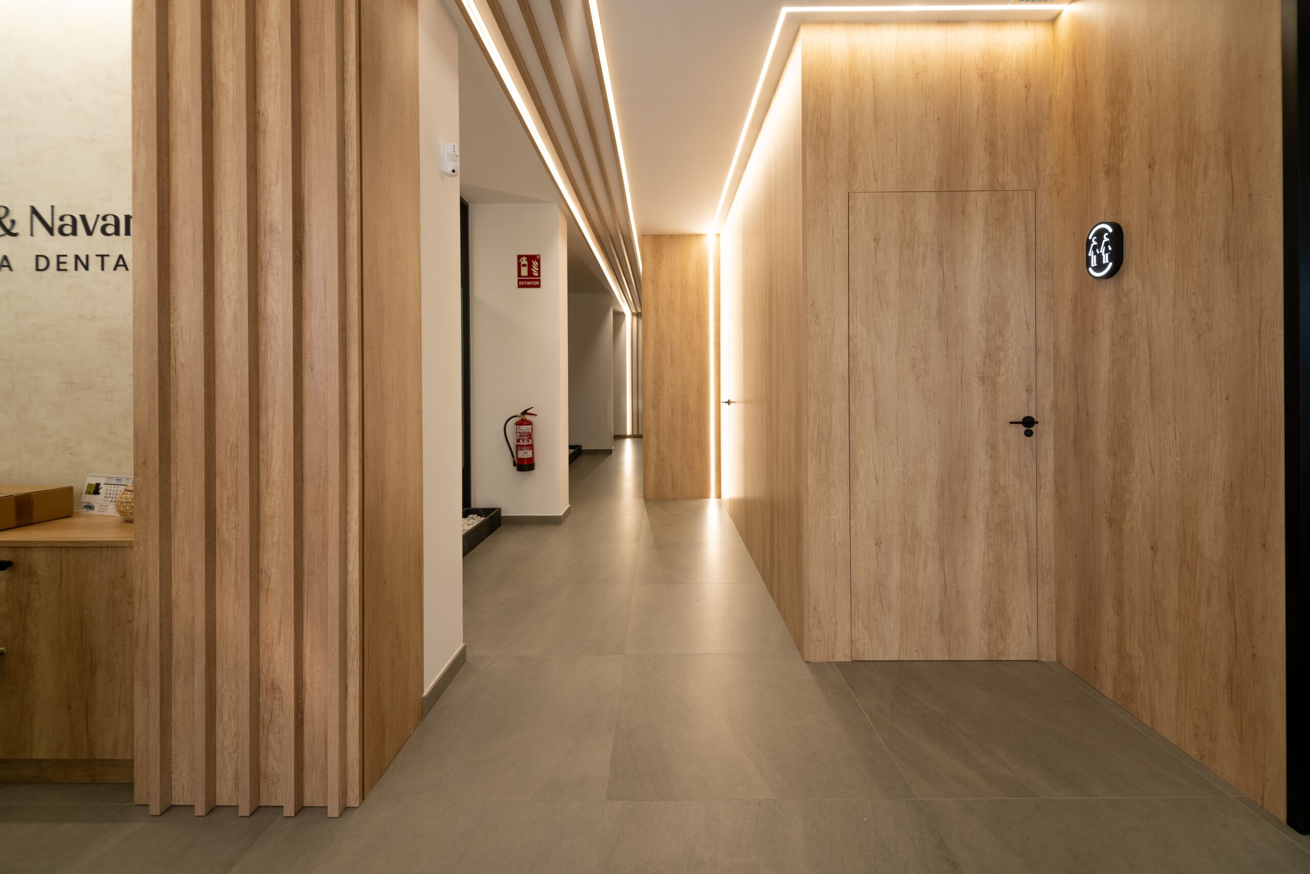 Pasillo principal con puertas a su izquierda y derecha decorado con madera